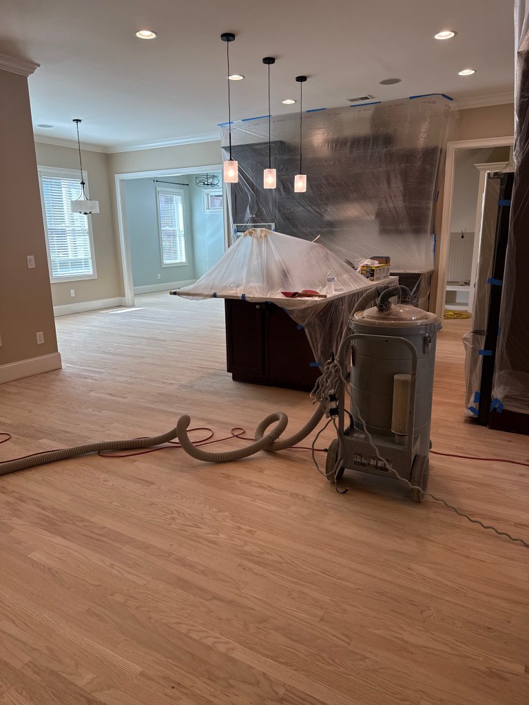 Dustless sanding rig with kitchen sealed in plastic during a hardwood refinish