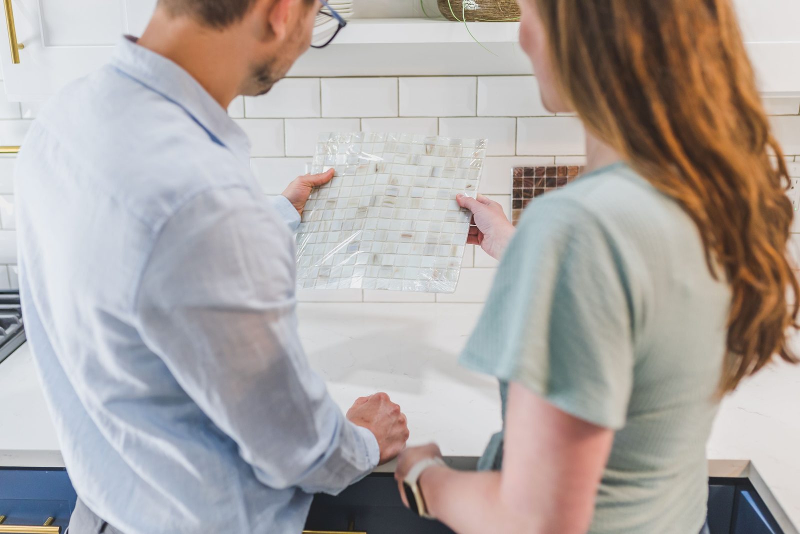 A couple selecting tile samples for a kitchen remodeling project