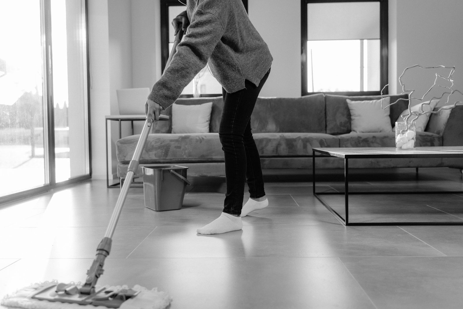 A person mopping the floor in a modern living room
