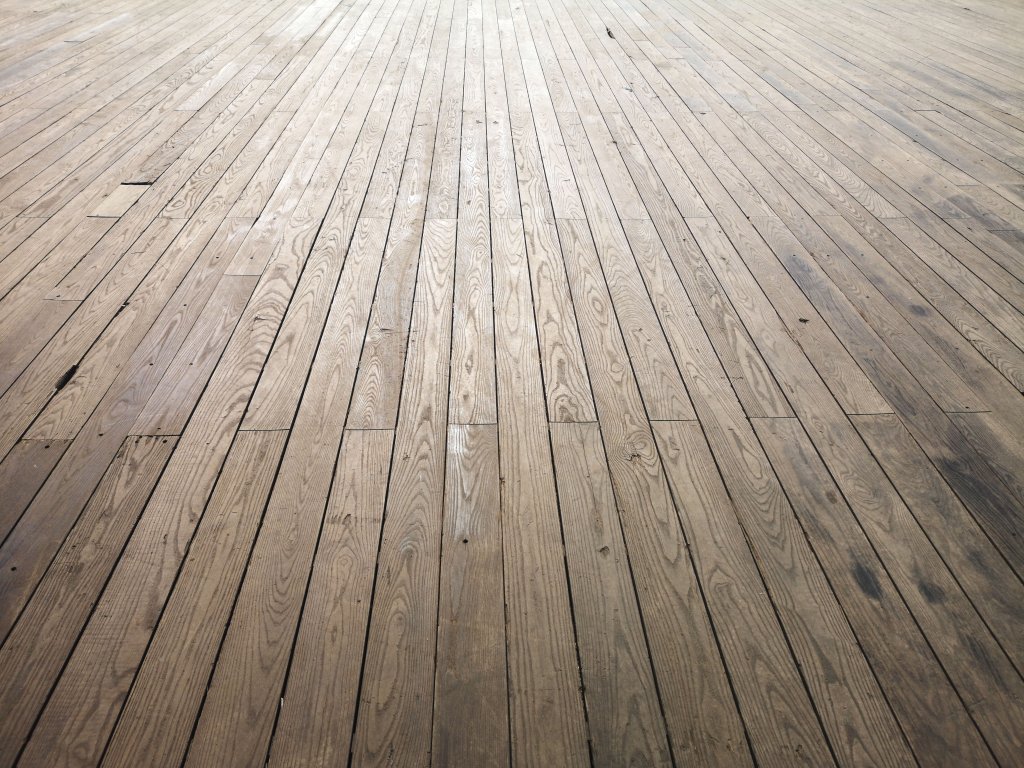 Aged wooden floor planks with visible grain and weathered texture.