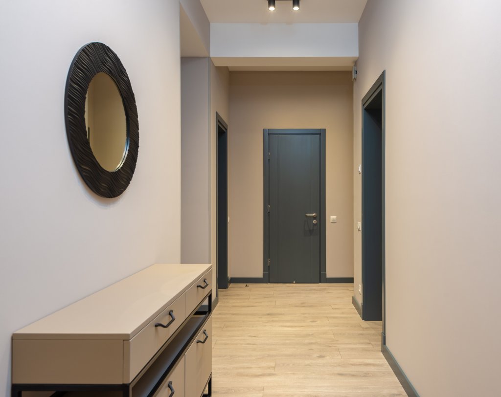 Contemporary apartment corridor with parquet floor and beige walls