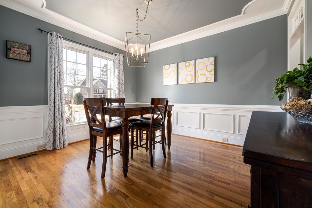 Sophisticated dining room with wooden floor, large window, and elegant decor, perfect for modern homes.