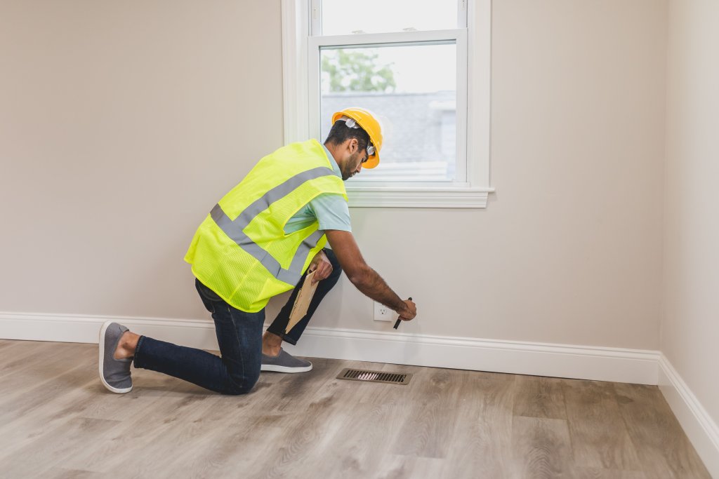 Worker inspecting a room corner during renovation